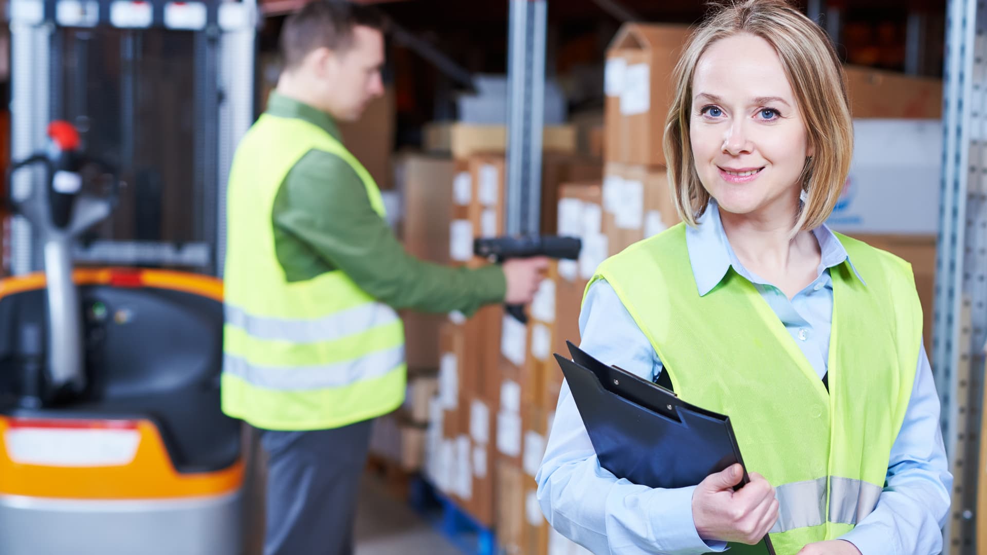 woman wearing fluro vest holding a clipboard
