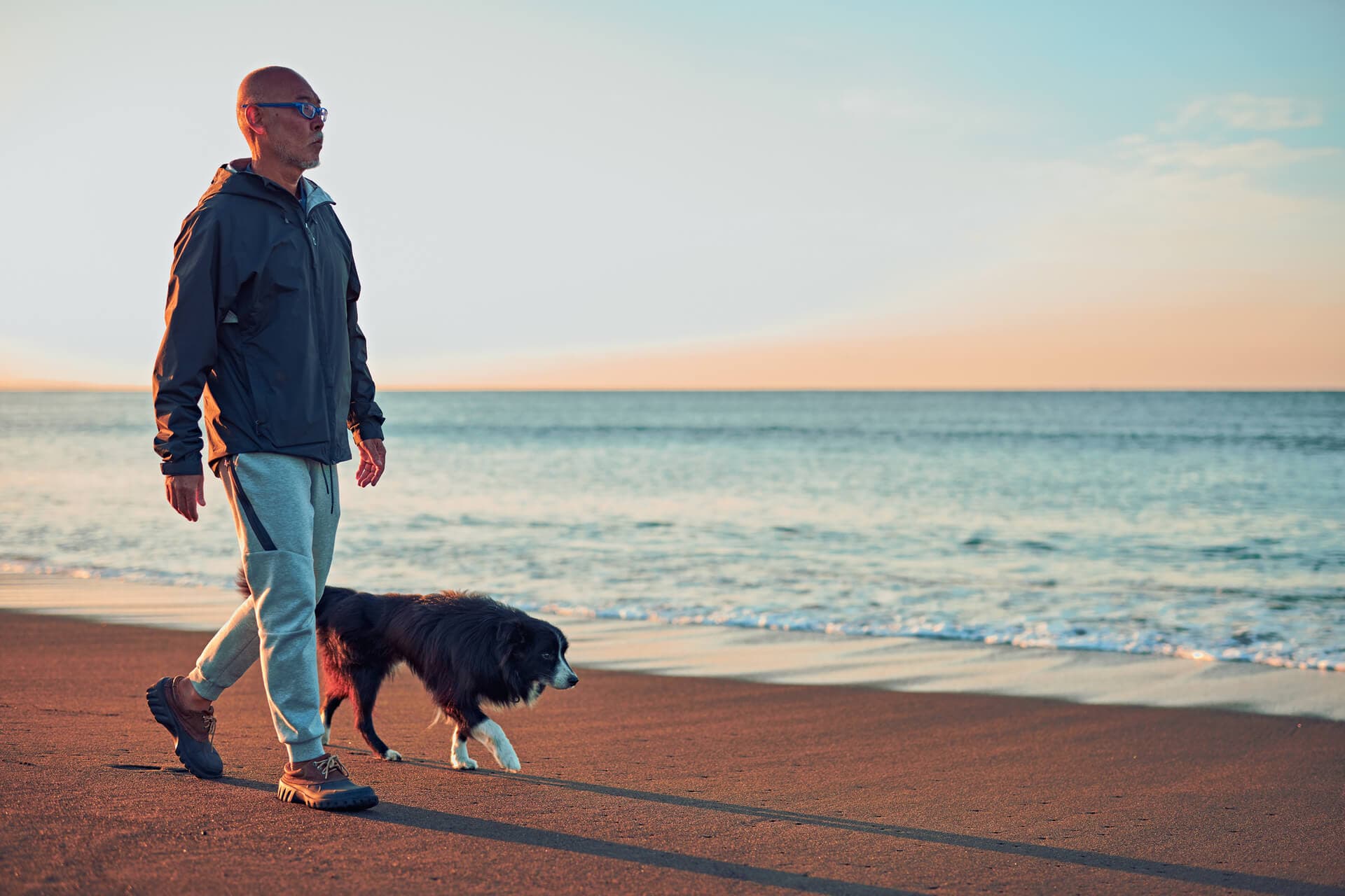 man walking his dog on the beach