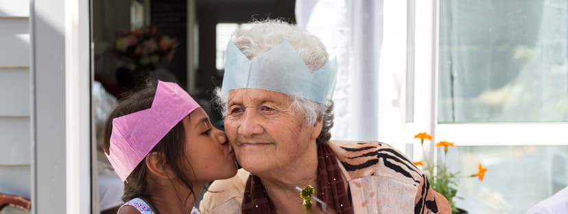 Young child and older woman celebrate festive occasion together 