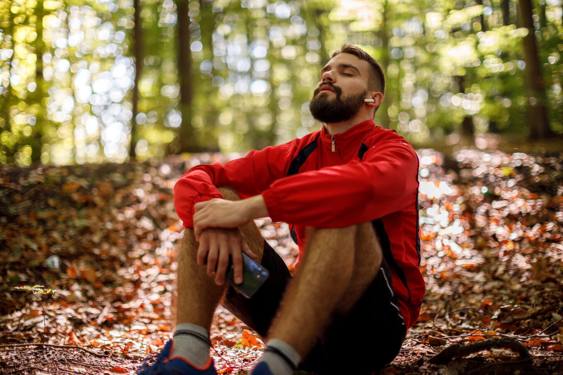 man sitting in the woods listening to music