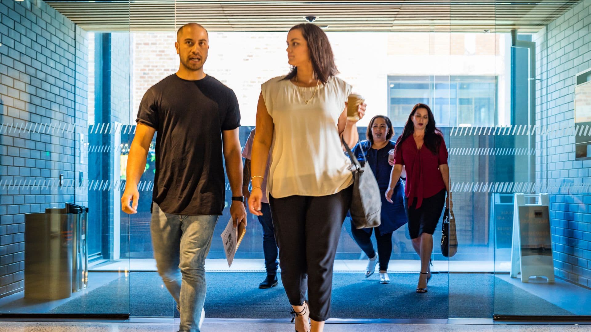 Employees returning to work walking into the office