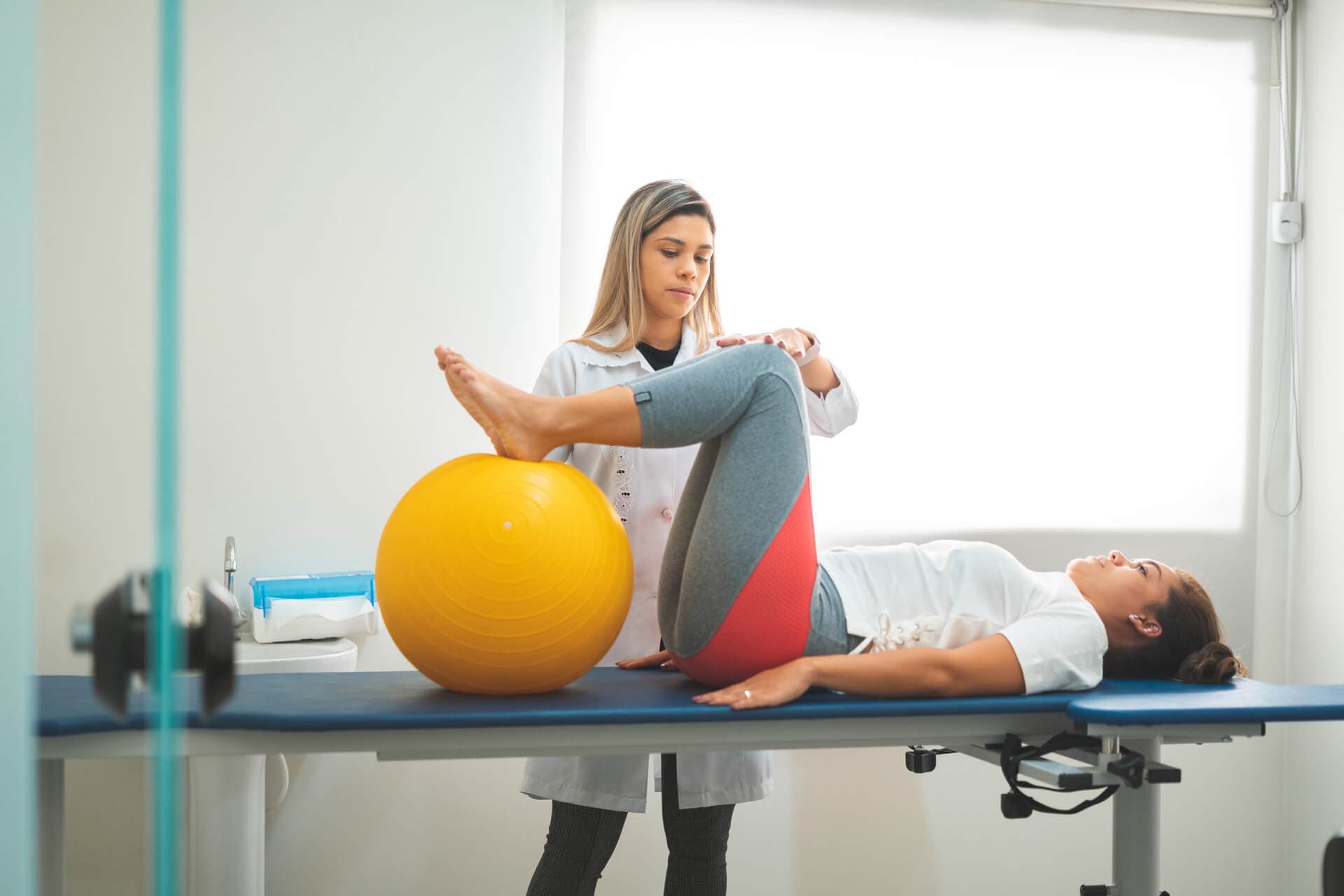 Physio assisting man with mobility exercise