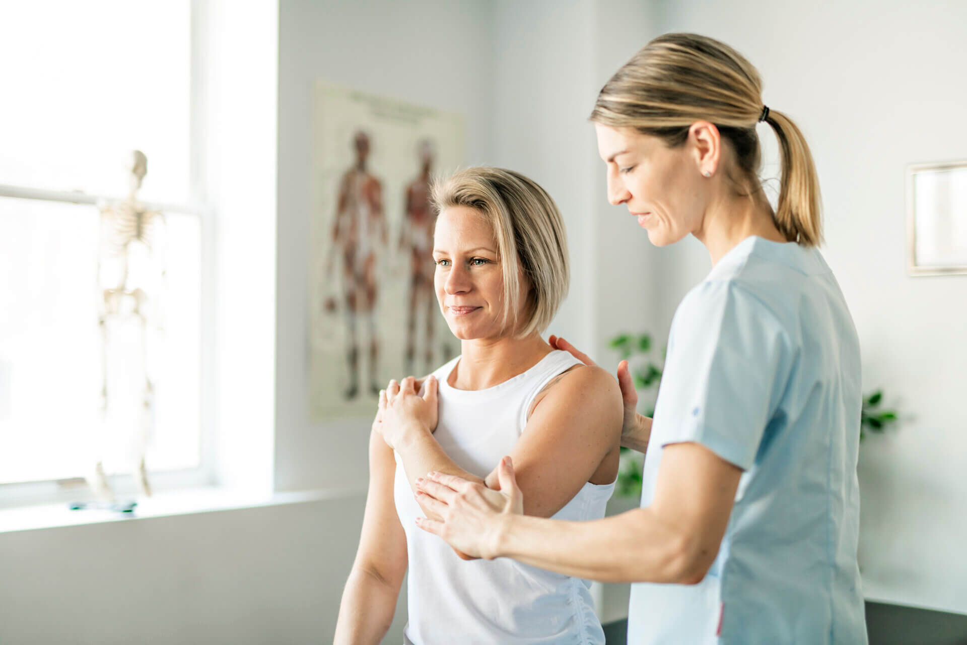 Physio helping patient test shoulder mobility