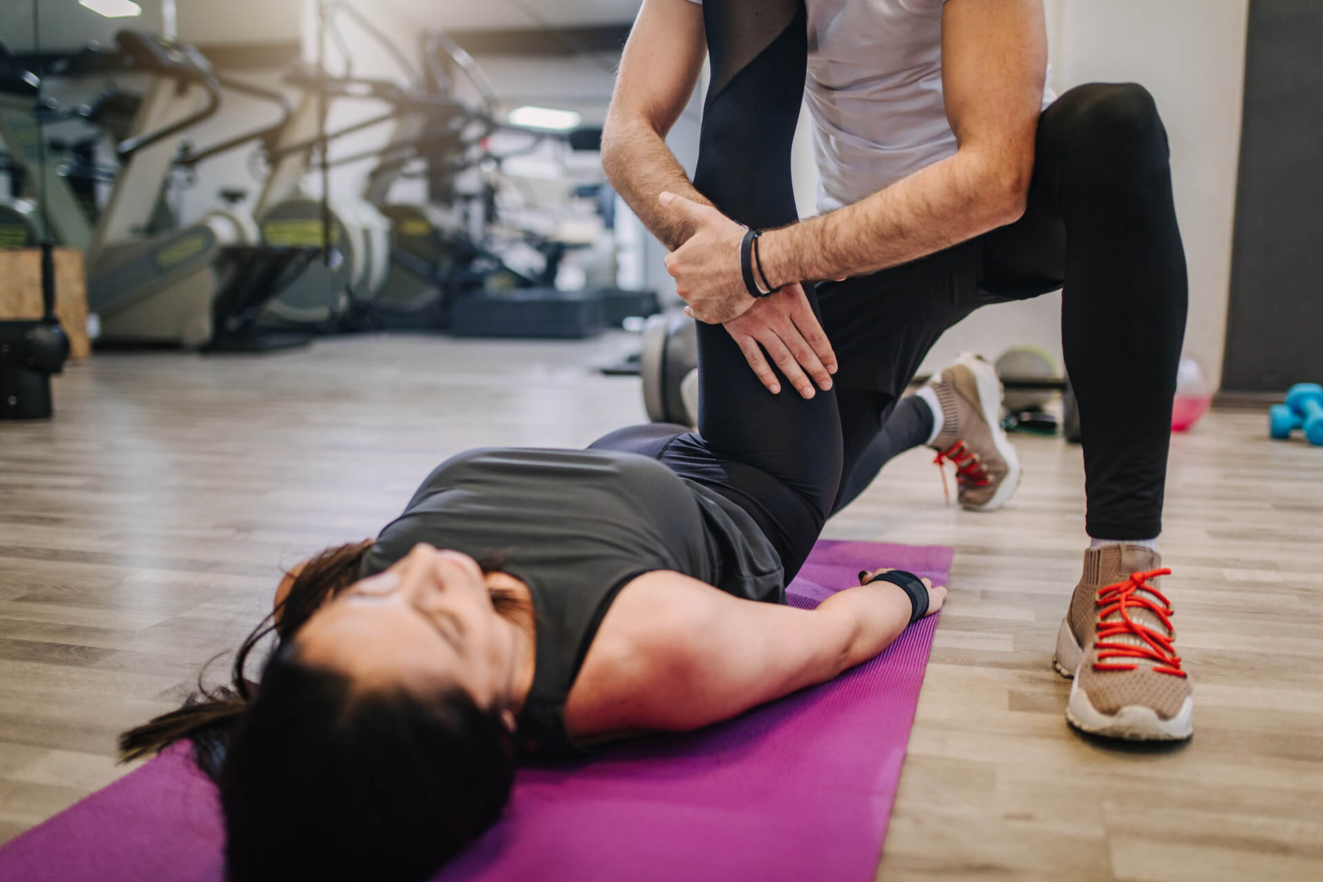 Physio applies stretch to patient in a gym