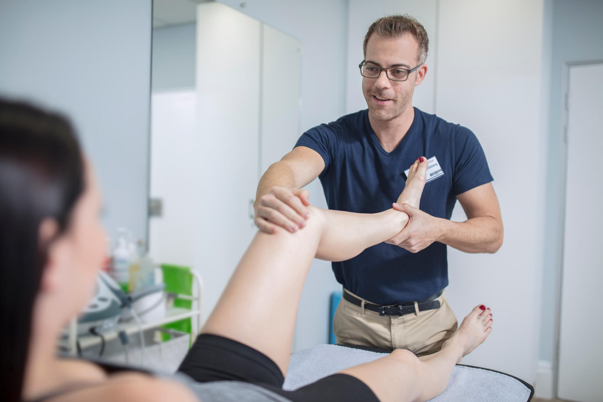 Physio assists patient with leg mobility