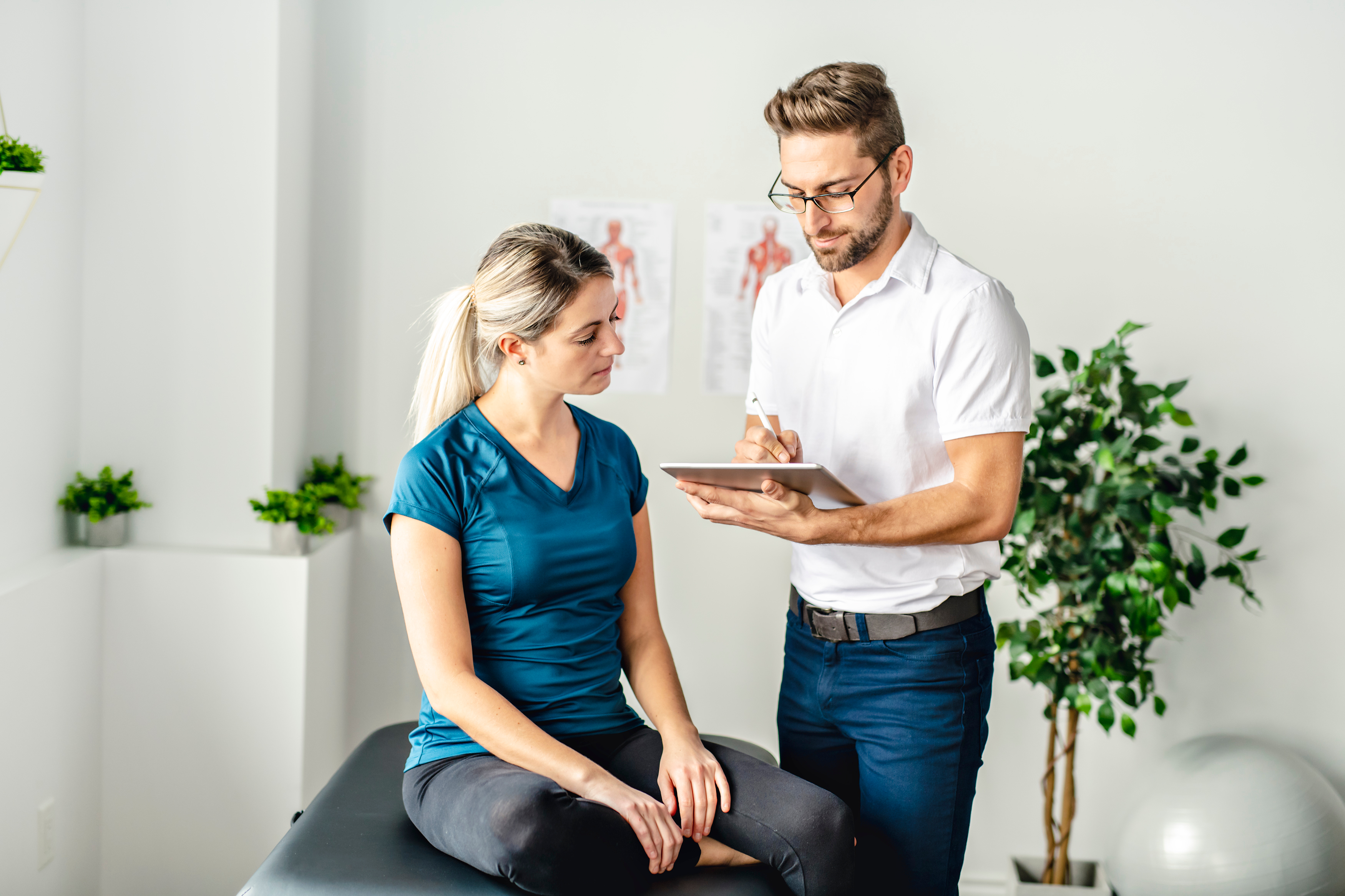 Physio assisting woman with assessment